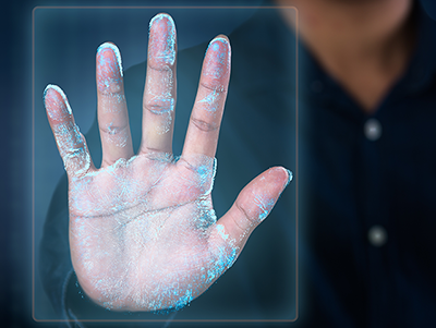Biometric authentication: A close up photograph of a hand pushed up against a square pane of glass, with pin pricks of blue light tracing the details of their palm