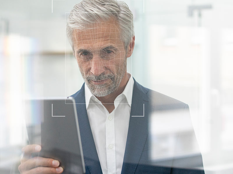 OneSpan - Man in suit, looking at his phone - scanning face