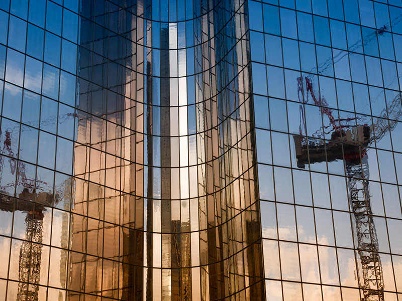  2 cranes reflected in the skyscraper