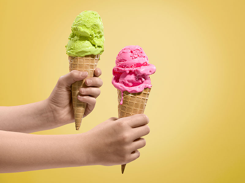 Hands holding ice-creams of different flavours