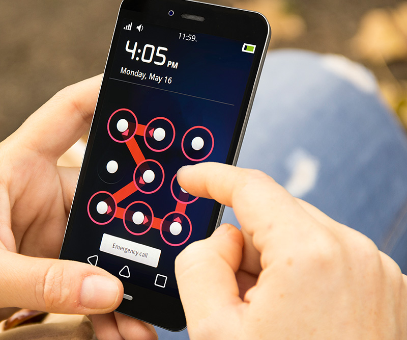 A pair of hands holding and swiping an unlock pattern on a mobile device