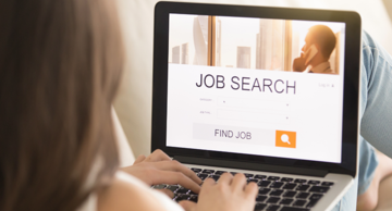 5 Tips to Protect Your Privacy Online During a Job Hunt - Over-the-shoulder view of a woman sitting with a laptop on her lap, with "Job search" on the header of a web page and "Find job" within a search bar in the bottom third of the screen