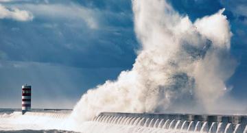 Scenic View Of Huge Wave Crashing Against Breakwater 