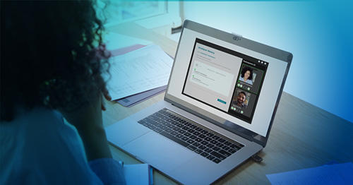 An over-the-shoulder view of a person with curly hair looking at an open laptop on a desk. On the desk, a video conference with an esignature interface is visible.